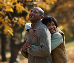 Black couple hugging in park in autumn