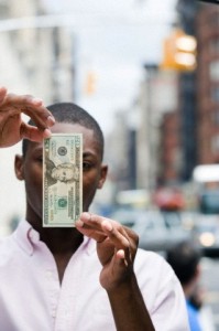 Man with 20 dollar bill in front of face