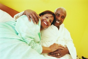 Senior Couple Lying in Bed With Their Arms Around Each Other