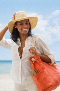Black woman carrying tote bag on beach