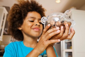 boy looking at pennies in piggy bank