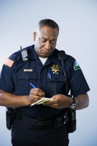African American male police officer writing ticket