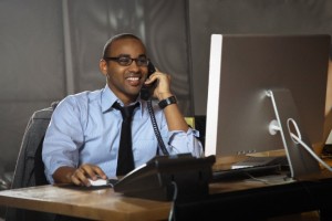 African American businessman working at desk and talking on telephone