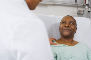 Doctor talking to Black man in hospital bed