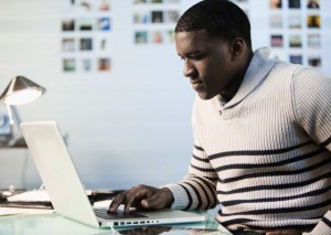 Black man typing on laptop