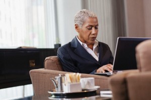 Businesswoman sitting in lobby using laptop